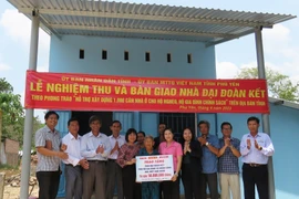 Bàn giao tiền hỗ trợ xây dựng nhà đại đoàn kết cho bà Nguyễn Thị Lánh, trú tại thôn Lãnh Tú, xã Xuân Lãnh, huyện Đồng Xuân. (Ảnh: TTXVN phát)