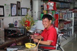 Ông Nguyễn Văn Quởn làm việc tại cửa hàng của mình. (Ảnh: Minh Trí/TTXVN)