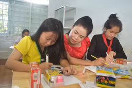 Cô Hoàng Thị Bảy hướng dẫn học sinh làm bài. (Ảnh: Nguyên Dung/TTXVN)