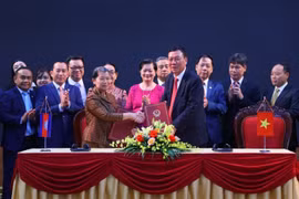Tổng Thanh tra Chính phủ Đoàn Hồng Phong và Phó Thủ tướng, Bộ trưởng Bộ Quan hệ với Quốc hội-Thượng viện và Thanh tra Campuchia Men Sam An trao đổi Biên bản hợp tác giữa hai cơ quan. (Ảnh: Văn Điệp/TTXVN)
