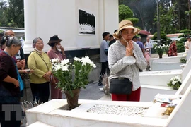 Du khách tỏ lòng thành kính trước mộ 10 nữ liệt sỹ thanh niên xung phong. (Ảnh: Công Tường/TTXVN) 