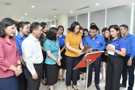 Tổng Giám đốc Thông tấn xã Việt Nam Vũ Việt Trang xem thông tin giới thiệu các Khu Di tích của TTXVN được tích hợp sẵn trong mã QR. (Ảnh: Minh Đức/TTXVN) 
