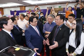 Thủ tướng Phạm Minh Chính thăm gian hàng trưng bày sản phẩm đổi mới sáng tạo. (Ảnh: Dương Giang/TTXVN) 