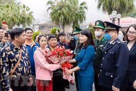 Lãnh đạo thành phố Móng Cái tặng hoa chúc mừng các đoàn khách quốc tế đầu tiên qua cửa khẩu quốc tế Móng Cái. (Ảnh: TTXVN phát)