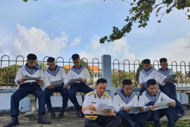 Các cán bộ, chiến sỹ đảo Trường Sa đọc thư của các em học sinh gửi từ Hà Nội. (Ảnh: Nguyễn Cúc/TTXVN)
