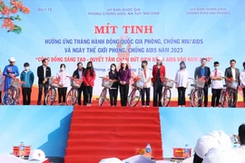 Bà Đào Hồng Lan, Bộ trưởng Bộ Y tế trao quà cho các cá nhân bị nhiễm HIV/AIDS tại lễ míttinh. (Ảnh: Hoàng Ngọc/TTXVN) 
