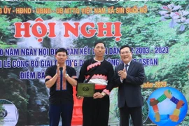 Giám đốc Sở Văn hóa Thể thao và Du lịch tỉnh Lai Châu Lương Chiến Công trao chứng nhận giải thưởng du lịch cộng đồng ASEAN cho điểm bản Sin Suối Hồ. (Ảnh: TTXVN phát)