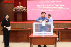 Bí thư Thành ủy Hà Nội Đinh Tiến Dũng quyên góp ủng hộ các nạn nhân trong vụ cháy chung cư mini tại quận Thanh Xuân. (Ảnh: Văn Điệp/TTXVN) 