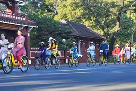 Đạp xe tuần hành hưởng ứng Tuần lễ Áo dài cộng đồng Huế 2023. (Ảnh: Mai Trang/TTXVN)