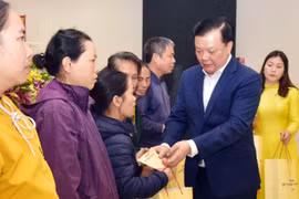 Bí thư Thành ủy Hà Nội Đinh Tiến Dũng tặng quà Tết cho các hộ gia đình có hoàn cảnh khó khăn trên địa bàn huyện Gia Lâm. (Ảnh: Văn Điệp/TTXVN)