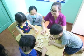 Can thiệp cho trẻ tự kỷ tại Đơn vị âm ngữ trị liệu-Phòng khám Đa khoa, Trường Đại học Y khoa Phạm Ngọc Thạch, thông qua trò chơi. (Ảnh: Đinh Hằng/TTXVN) 