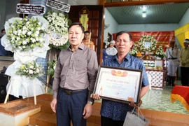 Ông Trần Phú Hùng, Phó Chủ tịch Hội đồng Nhân dân tỉnh Đắk Lắk trao Bằng Tổ quốc ghi công cho gia đình Đại úy Hà Tuấn Anh, cán bộ Công an xã Ea Tiêu, huyện Cư Kuin. (Ảnh: Quang Thái/TTXVN) 