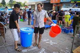 Người dân ở Khu Đô thị Thanh Hà lấy nước từ các xe bồn. (Ảnh: Hoài Nam/Vietnam+)