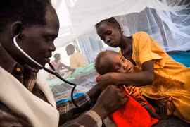 Nhân viên y tế khám bệnh cho một em nhỏ tại bệnh viện ở Malakal, Nam Sudan. (Ảnh: AFP/TTXVN) 