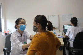 Bác sỹ khám tầm soát ung thư vú cho chị em phụ nữ. (Ảnh: Nguyễn Thảo/TTXVN) 