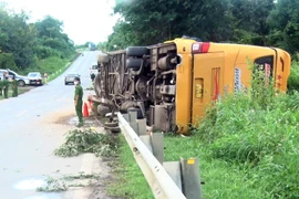 Lực lượng chức năng huyện Đăk Tô (tỉnh Kon Tum) bố trí lực lượng giải cứu những nạn nhân bị tai nạn trong vụ lật xe khách tại xã Tân Cảnh và phân luồng, điều tiết giao thông. (Ảnh: Khoa Chương/TTXVN)