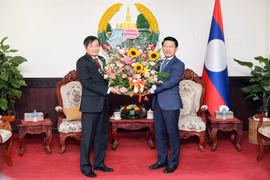 Đại sứ Nguyễn Bá Hùng tặng hoa chúc mừng 48 năm Quốc khánh nước Cộng hòa Dân chủ Nhân dân Lào. (Ảnh: Đỗ Bá Thành/TTXVN) 