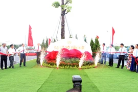 Các đại biểu thực hiện nghi thức gắn biển Đại lộ Võ Văn Kiệt. (Ảnh: Mạnh Tú/TTXVN)
