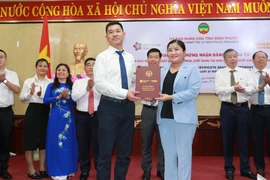 Chủ tịch Ủy ban Nhân dân tỉnh Bình Phước Trần Tuệ Hiền trao Giấy chứng nhận đầu tư cho Chủ tịch Công ty TNHH Shandong Haohua Tire. (Ảnh: Sỹ Tuyên/TTXVN)