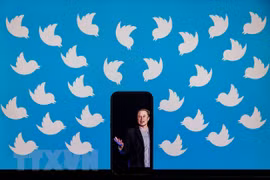 Tỷ phú Elon Musk và biểu tượng của Twitter. (Ảnh: AFP/TTXVN)