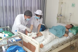 Các bác sỹ Bệnh viện Bà Rịa thăm khám vết mổ cho anh N.V.H (27 tuổi) sau khi anh được nối thành công cẳng chân bị đứt gần lìa do tai nạn giao thông. (Ảnh: TTXVN phát)