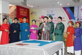 Đại diện thương hiệu áo dài Năm Tuyền giới thiệu bộ sưu tập áo dài ngũ thân qua câu chuyện Vinh quy bái tổ. (Ảnh: Mỹ Phương/TTXVN)