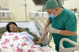 Bác sỹ Bệnh viện Bà Rịa-Vũng Tàu thăm khám cho bệnh nhân sau hậu phẫu. (Ảnh: Hoàng Nhị/TTXVN)