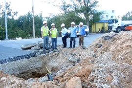 Cán bộ, kỹ sư của Khu Quản lý đường bộ 3 (Cục đường bộ Việt Nam) kiểm tra vị trí hố sâu để đưa ra giải pháp khắc phục. (Ảnh: Xuân Triệu/TTXVN