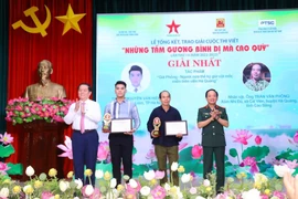 Trưởng Ban Tuyên giáo Trung ương Nguyễn Trọng Nghĩa và Trung tướng Trịnh Văn Quyết, Phó Chủ nhiệm Tổng cục Chính trị Quân đội Nhân dân Việt Nam trao giải Nhất cho các tác giả. (Ảnh: Văn Điệp/TTXVN)