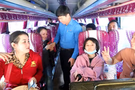 Ông Phạm Chí Tâm, Phó Chủ tịch Liên đoàn Lao động Thành phố Hồ Chí Minh lên tận ôtô tiễn công nhân về quê đón Tết. (Ảnh: Thanh Vũ/TTXVN)