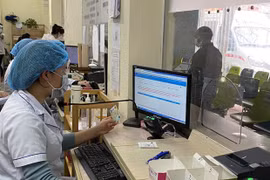 Làm thủ tục cho bệnh nhân đến khám, chữa bệnh bảo hiểm y tế bằng căn cước công dân. (Nguồn: Vietnam+) 