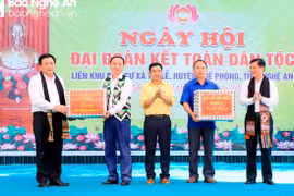 Ủy viên Bộ Chính trị Nguyễn Xuân Thắng và Bí thư Tỉnh ủy Nghệ An Thái Thanh Quý trao quà cho khu dân cư xã Tri Lễ, huyện Quế Phong. (Nguồn: Báo Nghệ An)
