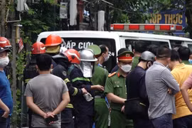 Lực lượng chức năng có mặt tại hiện trường vụ hỏa hoạn để tìm kiếm, cứu hộ, cứu nạn. (Ảnh: TTXVN phát)