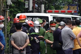 Lực lượng chức năng có mặt tại hiện trường vụ hỏa hoạn để tìm kiếm, cứu hộ, cứu nạn. (Ảnh: TTXVN phát)