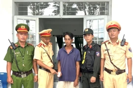 Đối tượng Ngô Văn Đậm (giữa) bị phát hiện dương tính với chất ma tuý trong khi điều khiển xe gắn máy. (Ảnh: TTXVN phát)