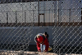 Người di cư vượt qua hàng rào biên giới Mỹ-Mexico tại El Paso, Texas, Mỹ. Ảnh minh họa. (Nguồn: AFP/TTXVN)