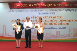 Ủy viên Bộ Chính trị, Bí thư Thành ủy Thành phố Hồ Chí Minh Nguyễn Văn Nên trao giải Nhất cá nhân cho 2 tác giả. (Ảnh: Thu Hoài/TTXVN)