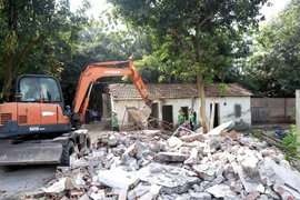 Lực lượng tham gia cưỡng chế thực hiện cưỡng chế tại khu vực hộ gia đình ông Nguyễn Văn Nam. (Ảnh: Hoàng Hùng/TTXVN) 