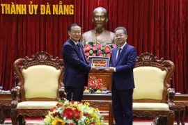 Bí thư Thành ủy Đà Nẵng Nguyễn Văn Quảng tặng quà lưu niệm cho Thứ trưởng Ban Tuyên truyền Trung ương Đảng cộng sản Trung Quốc Tôn Nghiệp Lễ. (Ảnh: Quốc Dũng/TTXVN)