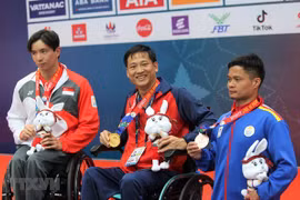 Nguyễn Hoàng Nhã (giữa) giành huy chương Vàng nội dung bơi ngửa nam 100m hạng thương tật S7, phá kỷ lục. (Ảnh: Hoàng Minh/TTXVN) 