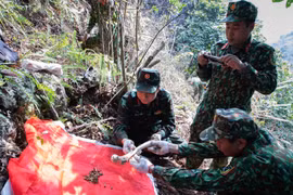 Cẩn thận quy tập những mảnh hài cốt còn sót lại của các liệt sĩ đã nằm lại trên chiến trường Vị Xuyên, sớm đưa các đồng đội trở về. (Ảnh: Hoàng Hiếu/TTXVN) 
