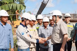 Thủ tướng Phạm Minh Chính với công nhân thi công Dự án nâng cấp Quốc lộ 30 đoạn Cao Lãnh- Hồng Ngự. (Ảnh: Dương Giang/TTXVN)