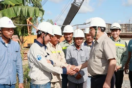 Thủ tướng Phạm Minh Chính với công nhân thi công Dự án nâng cấp Quốc lộ 30 đoạn Cao Lãnh- Hồng Ngự. (Ảnh: Dương Giang/TTXVN)