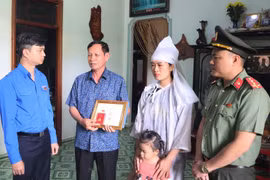 Trung ương Đoàn truy tặng Huy hiệu Tuổi trẻ Dũng cảm cho liệt sỹ, Đại úy Hà Tuấn Anh đến gia đình chiến sỹ. (Ảnh: Hoài Thu/TTXVN) 
