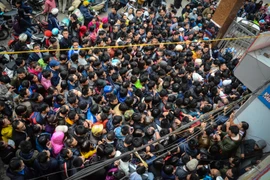 Chen nhau đến ngất xỉu lấy suất tiêm văcxin cho con tại Hà Nội. (Ảnh: Minh Sơn/Vietnam+)