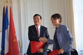 Bộ trưởng Phạm Vũ Luận và bà Najat Vallaud Belkacem trao đổi thỏa thuận hợp tác. (Ảnh: Tiến Nhất-Việt Sơn/Vietnam+)