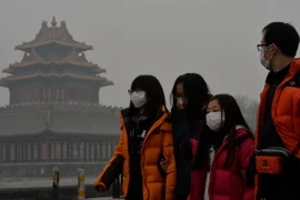 Khách du lịch đeo khẩu trang tránh bụi tại Bắc Kinh. (Nguồn: THX/TTXVN)