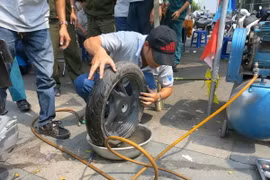 Vá lốp xe bị cán đinh. (Ảnh: Hải Âu/TTXVN)