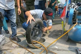 Vá lốp xe bị cán đinh. (Ảnh: Hải Âu/TTXVN)