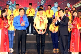 Chủ tịch nước Trương Tấn Sang và Bí thư thứ nhất Trung ương Đoàn Nguyễn Đắc Vinh trao vòng nguyệt quế và biểu trưng tuyên dương 63 Cháu ngoan Bác Hồ tiêu biểu toàn quốc. (Ảnh: Phạm Kiên/TTXVN)